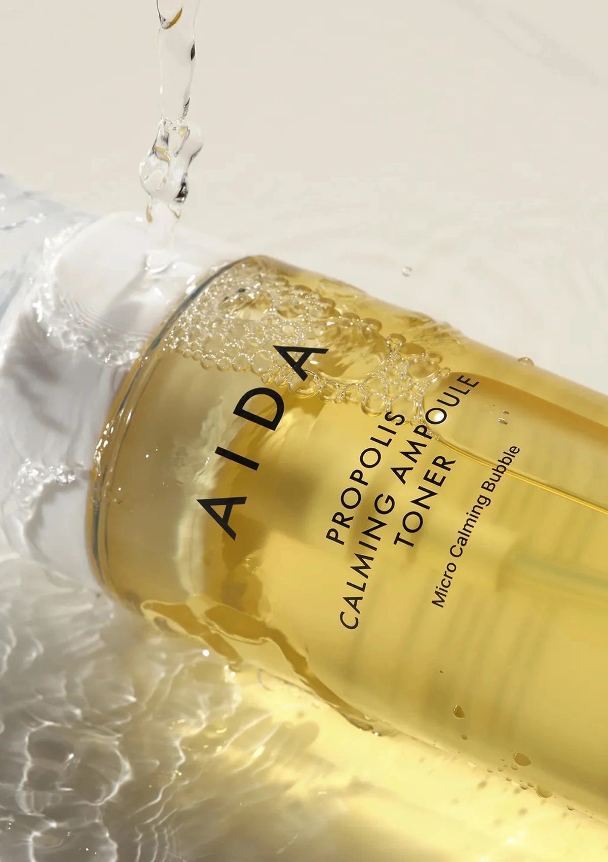 AIDA Propolis Calming Ampoule Toner bottle with water droplets on a light background